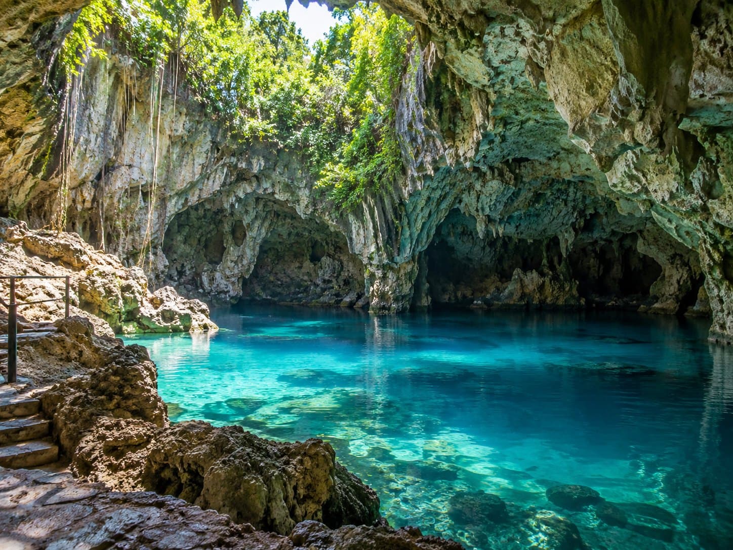 Lago de agua turquesa dentro de las cuevas de piedra caliza de Los Tres Ojos